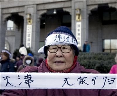 A Chinese protester  holds a banner reading No More Home during a protest in front of the Ministry of Construction in Beijing, China on Thursday, Jan. 24, 2008. (AP Photo/Andy Wong)