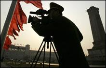 A policeman films near the Monument to the People's Heroes in Tiananmen Square on March 5, 2008. (AP Photo/Andy Wong)