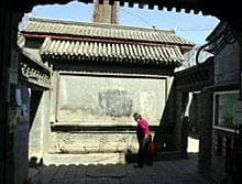 A woman walks through her courtyard home in one of Beijing's hutongs March 23, 2006. (AP Photo/Greg Baker)