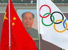 Olympic and Chinese flags fly near the portrait of late communist leader Mao Zedong on Tiananmen Gate in Beijing, Aug. 6, 2008.  (AP Photo/Greg Baker)