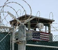 In this image reviewed by the U.S. Military, a guard tower is visible behind a razor-wire fence, at the detention camp at Guantanamo Bay U.S. Naval Base in Cuba, Wednesday, July 23, 2008. (AP Photo/Randall Mikkelsen, Pool)
