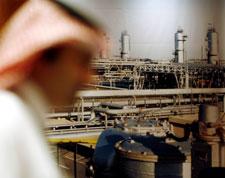 A Saudi official stands in front of a giant Saudi oil industry picture at a hotel in Jiddah, Saudi Arabia, June 21, 2008, ahead of a major oil summit. (AP Photo/Hasan Jamali)