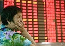 An investor looks at the stock price monitor at a private securities company in Shanghai, China. (AP)