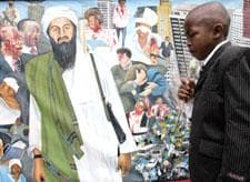 Victor Juma who lost his father during the 1998 U.S. embassy bombing in Nairobi, Kenya, stands in front of an artist's impression of the events at the memorial for the victims in Nairobi, Kenya, Aug. 7, 2008.