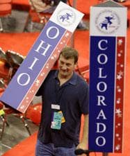 A worker carries the state standard for Ohio on the floor of the Republican National Convention in St. Paul, Minn., Sunday, Aug. 31, 2008. (AP Photo/Charlie Neibergall)