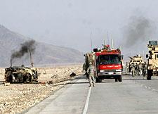 A damaged US vehicle (left) is seen after a suicide attack on a US military convoy in the Behsood district of Nangahar province, east of Kabul, Friday, Oct 10, 2008. (AP Photo/Rahmat Gul)