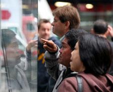 People stop to look through the windows of the Nasdaq MarketSite Tuesday, Oct. 14, 2008, in New York. (AP Photo/Mark Lennihan)