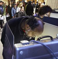 Voters huddle over booths as others fill the area behind waiting shortly after the polls opened in the basement of the Greenwood Christian Church Tuesday, Nov. 4, 2008, in Seattle. (AP Photo/Elaine Thompson)