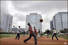 Employees of Applied Materials, a nanomanufacturing technology solutions company, play volleyball before a backdrop of glass-structured towers which house several information technology companies at the International Tech Park in Bangalore, India, Friday, Aug. 3, 2007. Bangalore, the capital of Indian outsourcing, is perhaps the closest India comes to Wall Street. India's IT firms derive 40 percent of their global revenues from financial services clients, with 61 percent of total sales from the U.S. and 30 percent from Europe. Now that proximity, which has fueled years of growth and transformed the city into one of India's most cosmopolitan, has put Bangalore on edge. (AP)