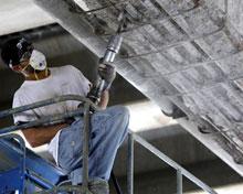 A member of a construction crew works under an Interstate 95 bridge in Philadelphia, Monday, July 28, 2008. A report released by the American Association of State Highway and Transportation Officials says one out of every four U.S. bridges needs to be modernized or repaired with the cost estimated to be at least $140 billion. (AP Photo/Matt Rourke) 