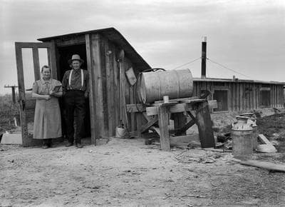 Lange’s original caption: “October 15, 1939. Dead Ox Flat, Malheur County, Oregon. The Wardlaw couple at entrance of basement dugout home.” 