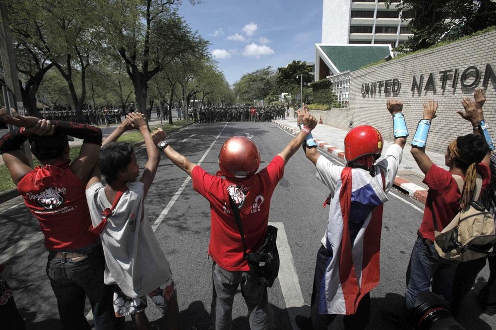 Thai anti-government protesters show surrender gesture against through a line of soldiers outside the government house in Bangkok, Thailand, Tuesday, April 14, 2009.  (AP)