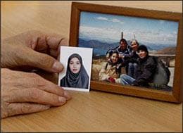 Akiko Saberi, the Japanese mother of imprisoned Iranian-American journalist Roxana Saberi, holds her daughter's photo next to a family picture in Tehran, Iran, on Saturday April, 25, 2009.