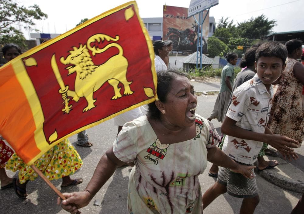 A Sri Lankan woman holds the national flag as she celebrates the victory of military over Tamil Tiger rebels, in Colombo, Sri Lanka, Monday, May 18, 2009. (AP)