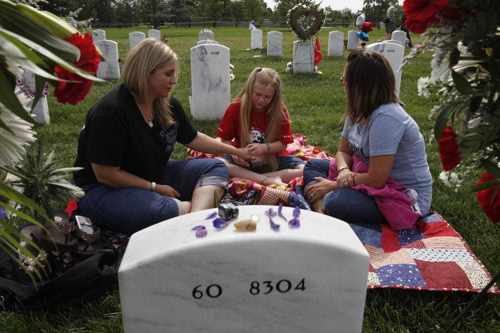 Stephanie Dostie, left, and her daughter Bayleigh Dostie, 9, from Fort Campbell, Ky., and Christy Young, from Fort Drum, N.Y., visit the grave of Dostie's husband, U.S. Army Sgt. First Class Shawn C. Dostie, who died serving in Operation Iraqi Freedom in 2005, Monday, May 25, 2009, on Memorial Day at Arlington National Cemetery in Arlington, Va. (AP)