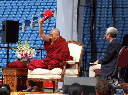 The Dalai Lama was presented with a red New England Patriots hat that he wore for much of his lecture on happiness at Gillette Stadium in Foxboro, Mass., Saturday. (Lisa Tobin/WBUR)