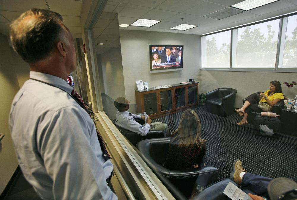 Roberto Zerbino, left, a sales and leasing consultant at the Williamson Cadillac dealership in Miami, watches through a window into the customer lounge as  President Barack Obama speaks to the nation about General Motors Corp. on tv. The president said he hopes GM would emerge quickly from bankruptcy court, and pledged up to $30 billion in additional federal assistance to help it get on its feet. (AP)