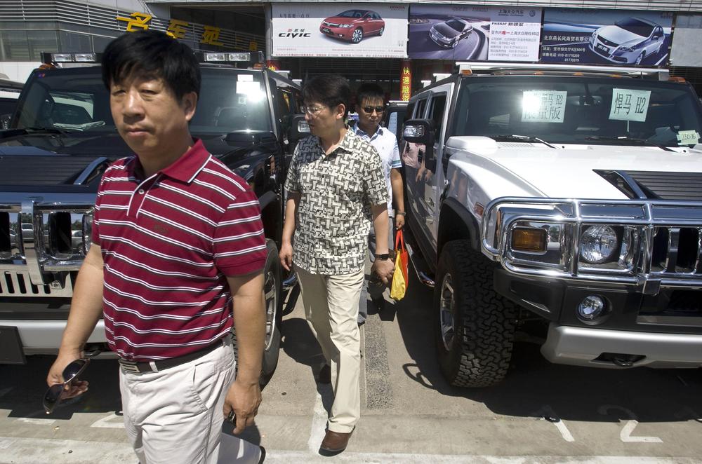 Customers walk between two Hummer vehicles in a parking lot of an auto market in Beijing Wednesday, June 3, 2009. China's Sichuan Tengzhong Heavy Industrial Machinery Co., said Tuesday it is buying the maker of luxury military-style SUVs from General Motors Corp. (AP)