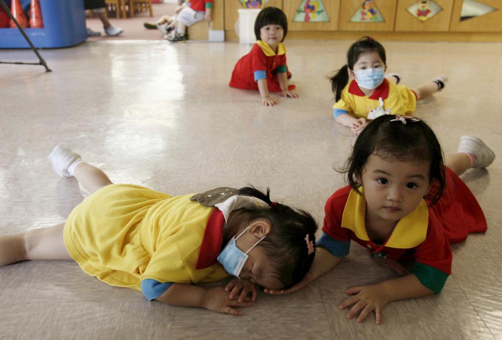 Students wearing mask play at a pre-school facility in Hong Kong Thursday, June 11, 2009. Hong Kong's government has ordered all kindergartens and primary schools closed for two weeks after a dozen students tested positive for the swine flu in the territory's first local cluster of cases on Thursday. (AP)