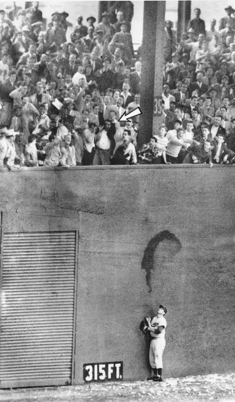 Brooklyn Dodgers left fielder Andy Pafko watches as the ball sails over the wall and drops into the lower deck of seats for New York Giants Bobby Thomson's three-run homer in the bottom of the ninth inning of the playoff game at the Polo Grounds in New York City on Oct. 3, 1951.  The roundtripper gave the Giants a 5 to 4 victory and the National League pennant.  The Giants will play the New York Yankees of the American League in the World Series scheduled to get underway at Yankee Stadium, Oct. 4.  (AP Photo)