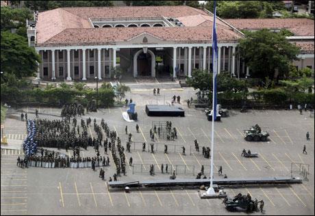Soldiers and police officers gather at the Libertad square in front of the presidential house in Tegucigalpa on Monday. Honduras' new leaders defied growing global pressure on Monday to reverse a military coup, arguing that they had followed their constitution in removing President Manuel Zelaya. (AP Photo)