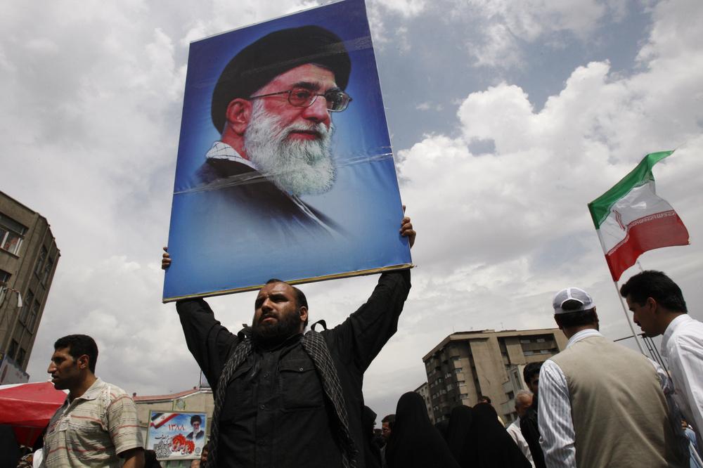 An Iranian man holds a poster of the supreme leader Ayatollah Ali Khamenei at the conclusion of the Friday prayers, in Tehran, Iran, Friday, June 19, 2009.  Iran's supreme leader said Friday that the country's disputed presidential vote had not been rigged, sternly warning protesters of a crackdown if they continue massive demonstrations demanding a new election. (AP Photo/Vahid Salemi)