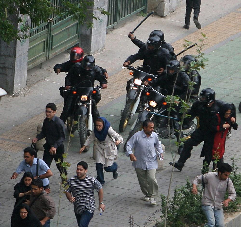 Iranian supporters of defeated Iranian presidential candidate Mir Hossein Mousavi are followed by Iranian riot-police in front of Tehran university during riots in Tehran, Iran, Sunday, June 14, 2009. Iranian youth opposed to President Mahmoud Ahmadinejad took to the streets Sunday, setting trash dumpsters and tires on fire, in a second day of clashes triggered by voter fraud claims. (AP Photo)