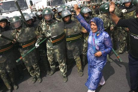 An Uighur woman protests near paramilitary police in Urumqi on Tuesday. Ethnic Uighurs scuffled with armed police Tuesday in a fresh protest in the western region of Xinjiang, where at least 156 people have been killed and more than 1,400 people arrested in western China's worst ethnic violence in decades. (AP Photo)
