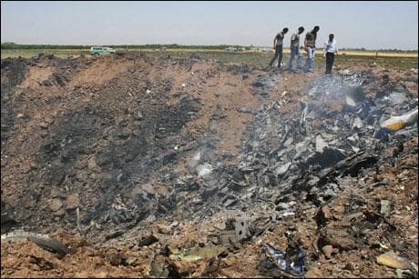 In this photo released by the semi-official Iranian Students News Agency (ISNA), people walk at the scene of a plane crash near the village of Jannatabad, around 75 miles northwest of Tehran in Iran on Wednesday. (AP Photo)