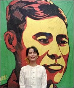 Burmese democratic leader Aung San Suu Kyi smiles as she poses for a picture in front of a large portrait of her late father, independence leader Aung San who was assassinated in 1947. (AP)