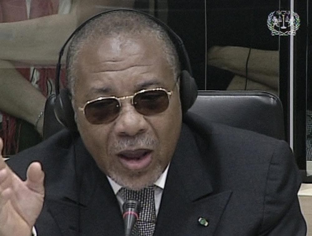 In this image made from television broadcast Tuesday, July 14, 2009 by the International Criminal Court, former Liberian President Charles Taylor, address the U.N. backed Special Court for Sierra Leone. Wearing a gray double-breasted suit and dark glasses, Taylor spoke confidently as he introduced himself to the three-judge panel as the 21st president of the Republic of Liberia. It was his first time on the witness stand.  Taylor is charged with 11 counts of murder, torture, rape, sexual slavery, using child soldiers and spreading terror during Sierra Leone's 1991-2002 civil war. He is the first African leader to stand trial for war crimes.  (AP Photo/ICC)