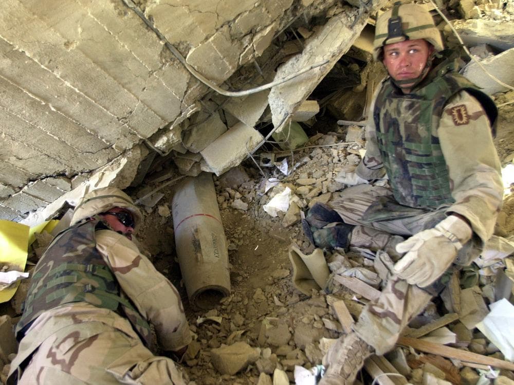 Staff Sgt. Jeffrey Elliott of Lowell, Ind., left and Sgt. Matt Chapman of Annapolis, Md. listen to another member of their explosive ordinance disposal team as they unearth a missile Friday, May 9, 2003 in Baghdad, Iraq. The team from the 18th Ordinance Company based at Fort Bragg, N.C., have been working almost constanly trying the remove munitions from Iraq's capital. (AP Photo/Chris Tomlinson)