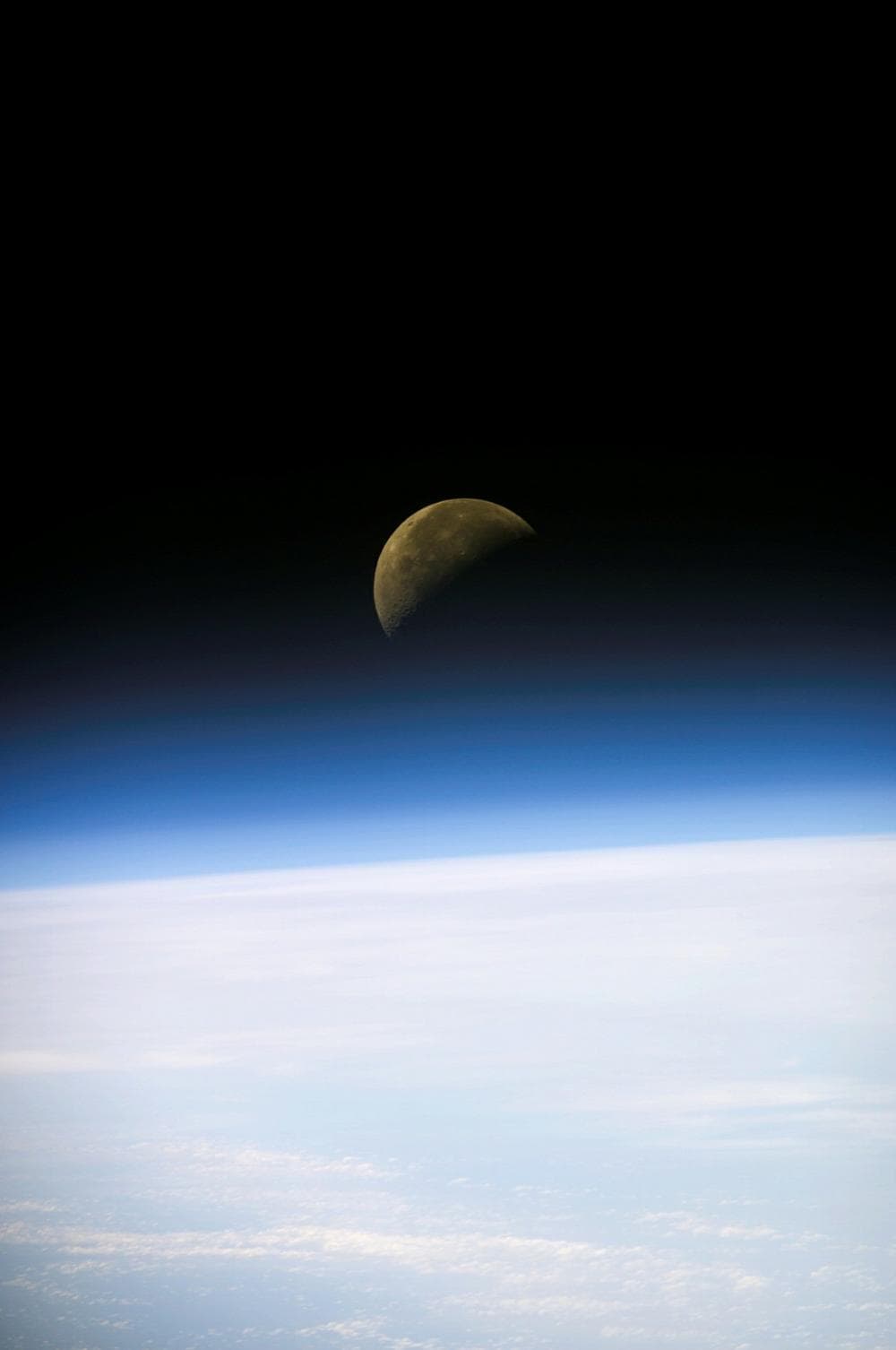 A quarter moon is visible in this oblique view of Earth's horizon and airglow, recorded with a digital still camera on Sunday, Jan. 26, 2003, aboard the Space Shuttle Columbia. The six Americans and one Israeli aboard Columbia marked their 12th day in space Tuesday, Jan. 28, 2003. Their round-the-clock laboratory research mission, featuring more than 80 experiments, is due to end with a landing back at Kennedy Space Center on Saturday. (AP Photo/NASA)