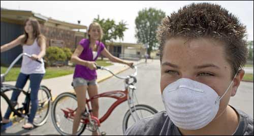 In this May 2009 photo, Fred Moiola Elementary School students ride their bikes outside the closed school in Fountain Valley, Calif. The school was  closed for swine flu sanitizing. (AP)