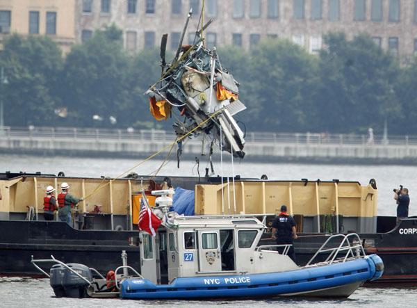 The wreckage of a helicopter is lifted by crane from the Hudson River and placed on a boat as seen from Hoboken, N.J., on Sunday. (AP Photo/Seth Wenig)