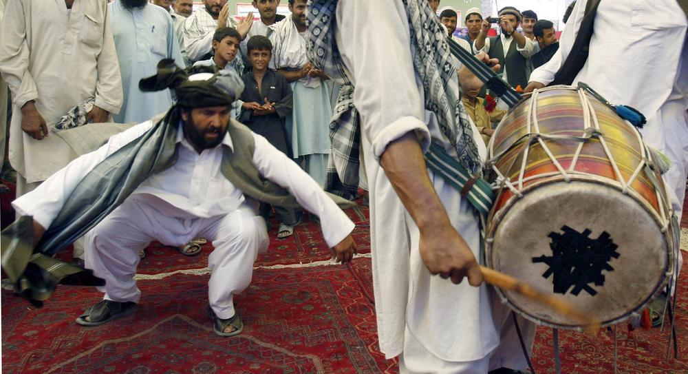 An Afghan man dances, left, as another plays a drum during an election campaign rally for  presidential candidate and former Finance Minister Ashraf Ghani Ahmadzai in Jalalabad, Nangarhar province east of Kabul, Afghanistan, Monday, Aug. 17, 2009. Afghans will head to the polls on Aug. 20 to elect a new president for the second time in the country's history. (AP Photo/Rahmat Gul)