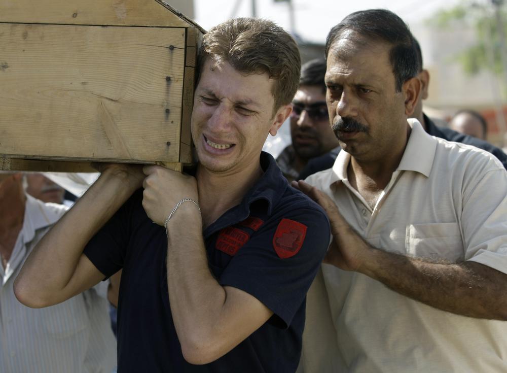 Men carry the coffin of a relative, killed in Wednesday's bombing, in Baghdad, Iraq, Thursday, Aug. 20, 2009. A string of blasts killed at least 100 people in Baghdad on Wednesday. More than 500 people also were wounded when nearly simultaneous truck bombs struck Iraq's Foreign and Finance ministries on Wednesday _ the deadliest day of coordinated bombings in more than a year. (AP)