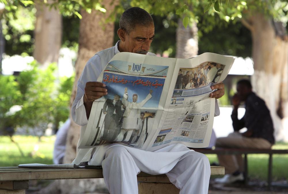 A Libyan man reads a newspaper showing photographs of the arrival of Abdel Baset al-Megrahi, in a park in the capital Tripoli, Libya, Monday, Aug. 24, 2009. Scottish legislators held an emergency debate Monday on the government's decision to release the Lockerbie bomber as critics claimed the act could severely damage relations with the United States. (AP)