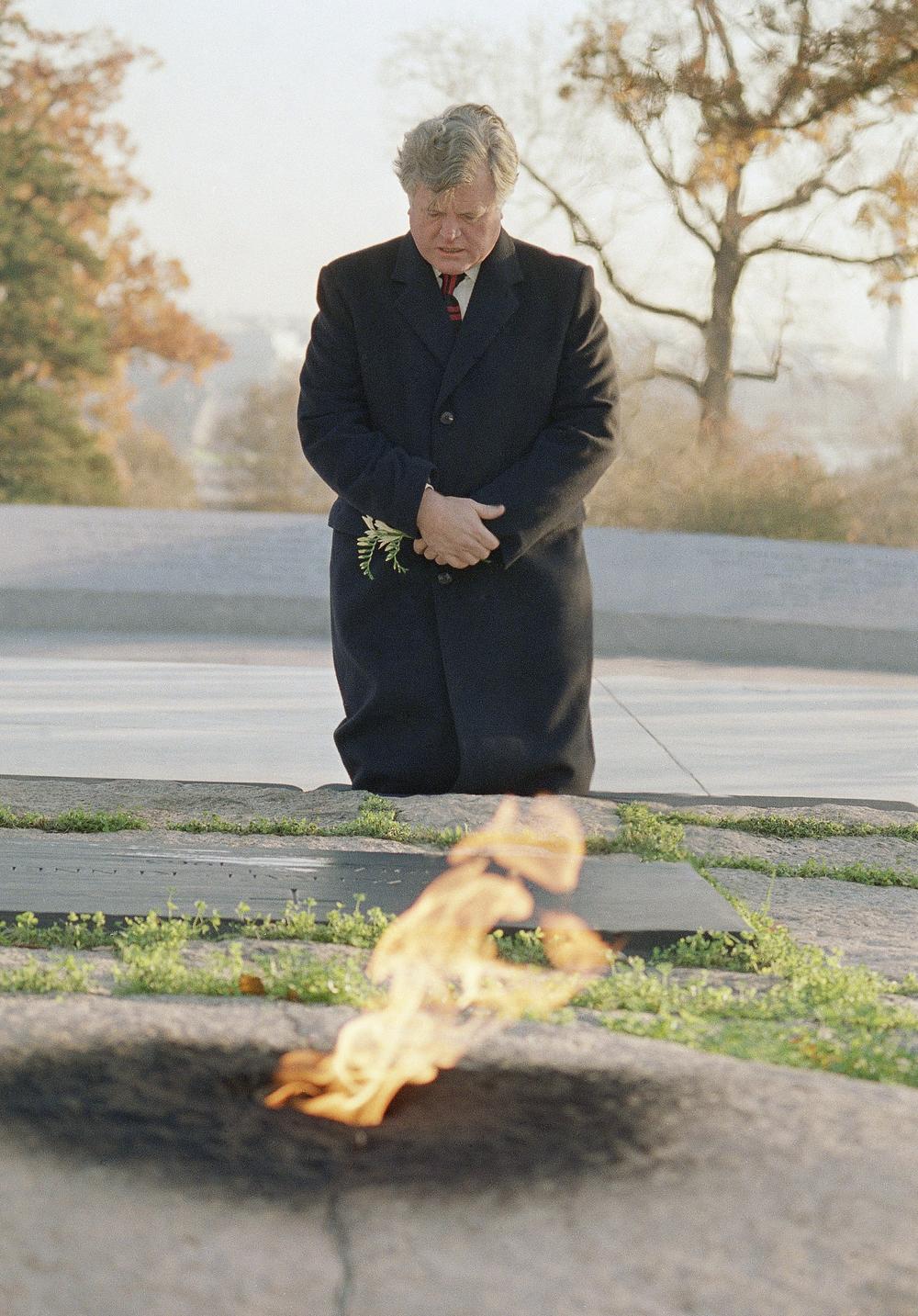Sen. Edward Kennedy, D-Mass., Kneels at the gravesite of his brother, President John F. Kennedy, in  Arlington Cemetery Saturday, Nov. 22, 1986, the 23rd anniversary of the President's assassination in Dallas, Texas.   In foreground is the eternal flame that marks the grave.  (AP)