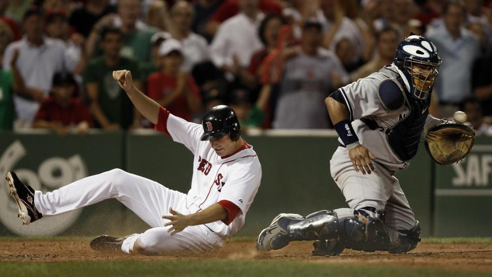 Red Sox's Rocco Baldelli slides home safely as Yankees catcher Jose Molina gets the throw during the second inning at Fenway on Sunday. (AP)