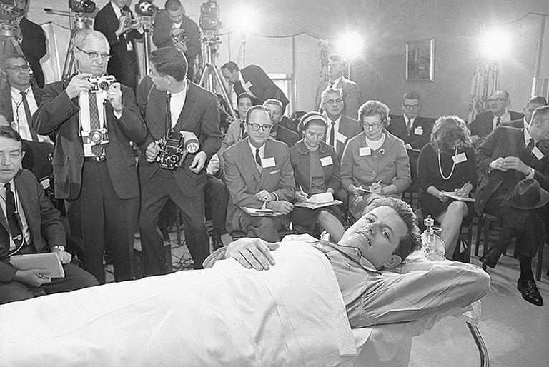 In June 1964, Kennedy broke his back in a plane crash that killed the pilot of the plane and one of his aides. He spent months confined to an orthopedic frame, recounting details of the experience at an October press conference. (AP)