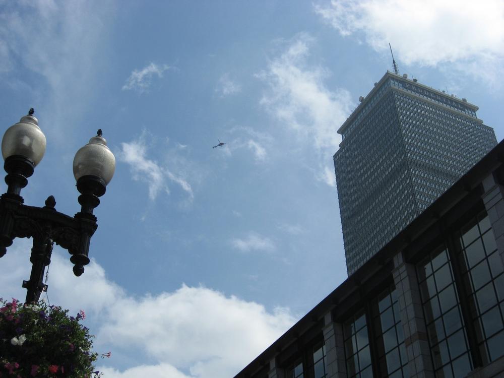 A helicopter flies near the Prudential Center in Boston on Friday. (Allison Dukakis/WBUR Intern)