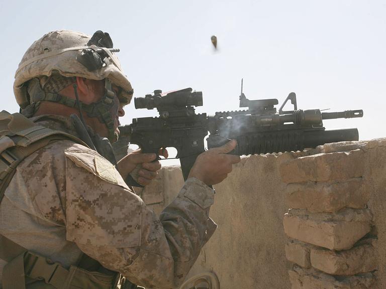 A U.S. Marine of Golf Company, 2nd Battalion, 3rd Regiment fires on Taliban positions from a rooftop in the village of Dahaneh Wednesday,