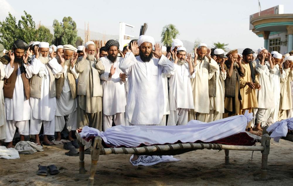 Afghan men offer funeral prayers behind the bodies of civilian killed in a suicide attack in Mehterlam, the capital of Laghman province, east of Kabul, Afghanistan, on Wednesday. A Taliban suicide bomber detonated his explosives as Afghanistan's deputy chief of intelligence visited a mosque east of Kabul on Wednesday, killing the Afghan official and 22 others. (Rahmat Gul/AP)