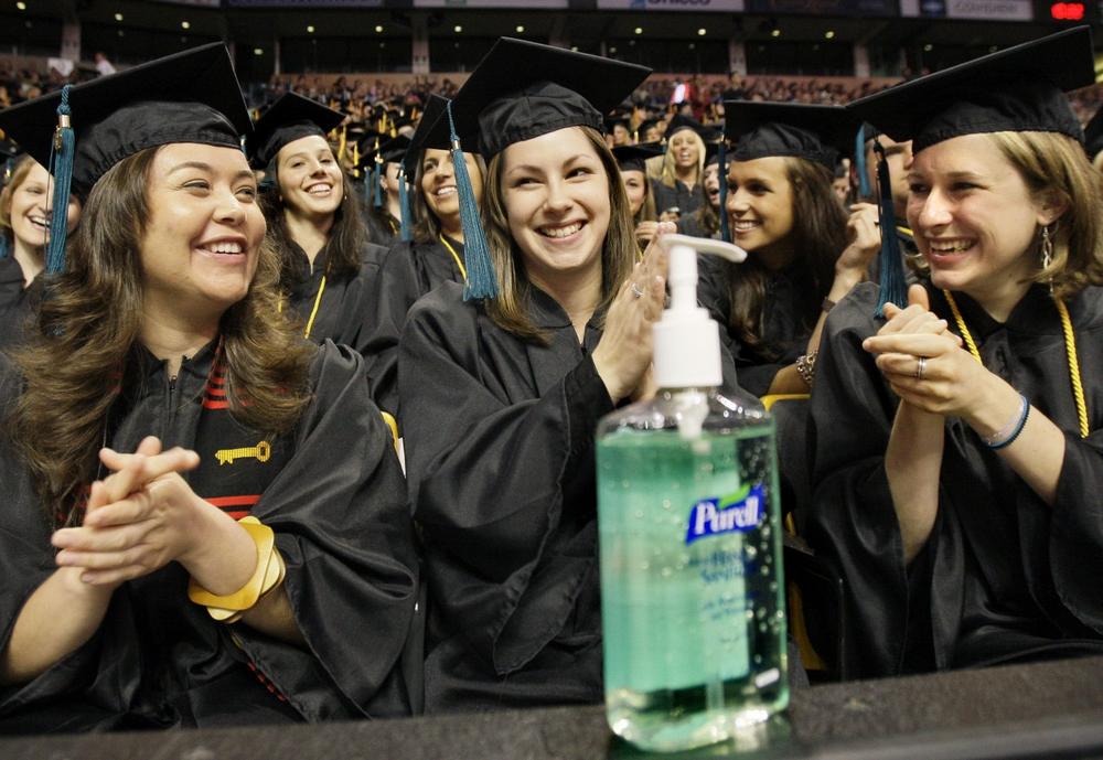 Alejandra Calderon, Stephanie Calefati and Sharon Casey applied liquid hand sanitizer at the start of Northeastern University's commencement ceremony in Boston on May 1. (Elise Amendola/AP)