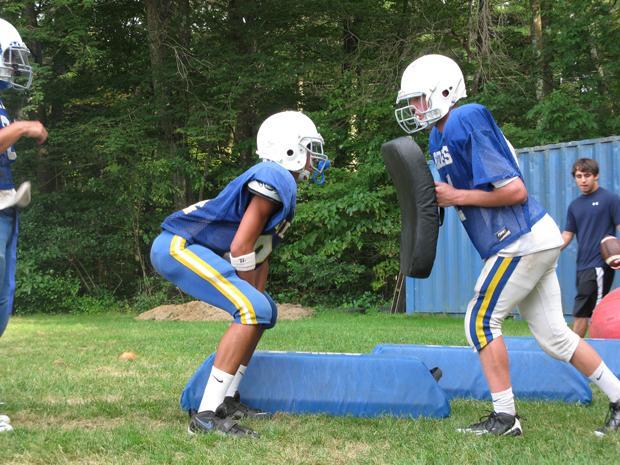 Dover-Sherborn High School football players practice correct tackling-technique in an early season work out. The athletic department launched a computerized concussion management program at the high school this fall. (Meghna Chakrabarti/WBUR)