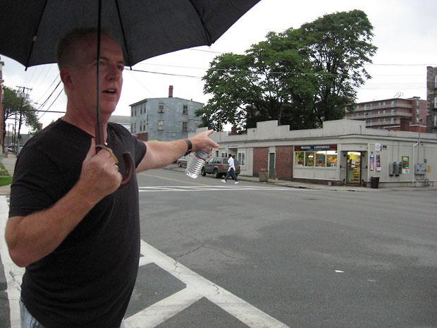 Richie Farrell points out a block in Lowell he used to frequent as a homeless drug addict. (Huda Alhamda for WBUR)