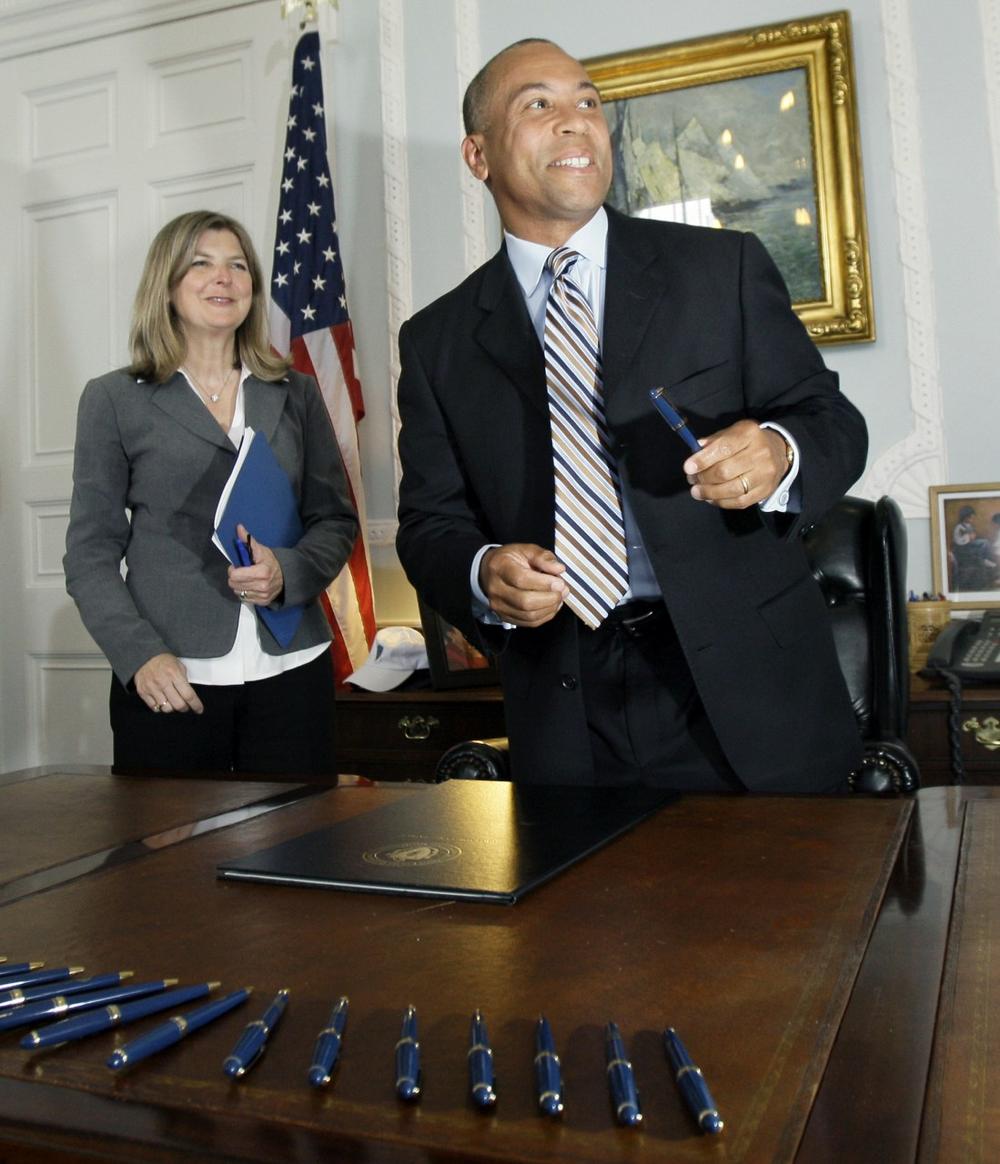 Gov. Deval Patrick smiles after signing a $27 billion state budget as Secretary of Administration and Finance Leslie A. Kirwan, left, looks on in his Boston office, June 29, 2009. (AP)