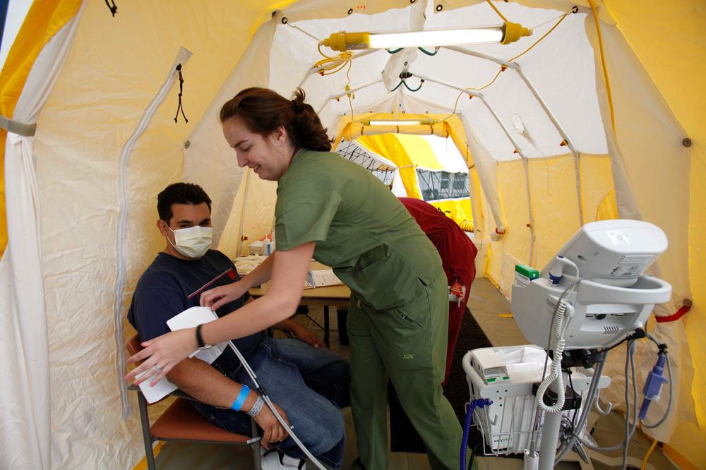 Nurse Torrey Jones takes a blood pressure cuff off of patient Art Arteaga under a triage tent set up outside Arrowhead Regional Medical Center in Colton, Calif. to treat emergency room patients who exhibit signs of the flu on Friday, May 1, 2009. (AP)