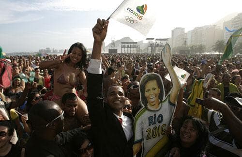 A Barack Obama impersonator poses next to a cardboard cutout image of Michelle Obama as Rio residents celebrate the nomination to host the 2016 Olympic Games at the Copacabana beach, in Rio de Janeiro, Friday, Oct. 2, 2009. (AP)